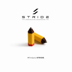 Könnte beinhalten: Zwei gelbe bleistiftförmige Objekte mit braunen Spitzen und roten Enden. Darüber steht der Text STRIDE PREMIUM BIKE ACCESSORIES mit einem Logo. Darunter steht der Text #findyourSTRIDE. Das Design ist vor einem schlichten weißen Hintergrund.