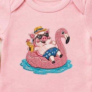 Könnte beinhalten: Hellrosa Baby-Body mit gesticktem Design. Es zeigt ein Schwein mit Sonnenbrille und Hut, das auf einem rosa Flamingo-Schwimmer in blauem Wasser entspannt. Das Schwein hält einen Cocktail. Der Body ist aus weichem Material.