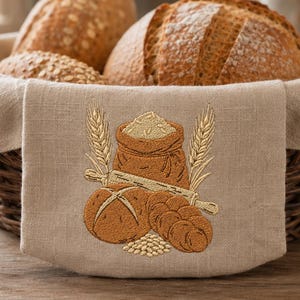 May include: A dark brown woven wicker basket lined with a light beige fabric featuring an embroidered design of a sack of flour, a rolling pin, two loaves of bread, and wheat stalks. The basket is filled with several round, crusty loaves of bread.