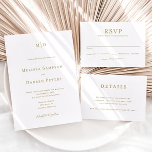 May include: A wedding invitation suite with a white background and gold text. The invitation features the couple's names, wedding date, and location. The RSVP card includes space for guests to indicate their attendance. The details card provides a website for more information.