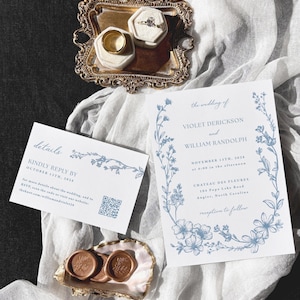 May include: Wedding invitation suite featuring a gold ring, a diamond ring, and wax seals. The invitation and reply card have blue floral designs and text. The invitation includes the names Violet Derickson and William Randolph.