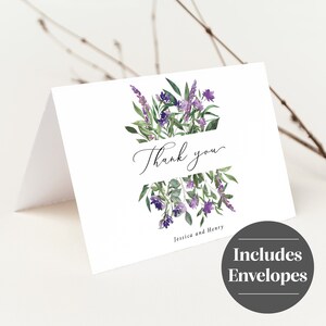 Op de afbeelding: Witte gevouwen bedankkaart met een aquarel bloemenontwerp in paarse en groene tinten. De woorden "Thank you" zijn geschreven in elegant schrift, met de namen "Jessica and Henry" eronder. Inclusief enveloppen.