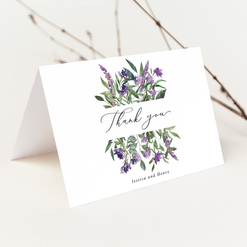 Op de afbeelding: Een witte gevouwen bedankkaart met aquarel bloemstukken in paars en groen. De woorden "Thank you" zijn geschreven in elegant schrift, met de namen "Jessica and Henry" eronder.