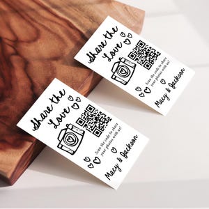 K&ouml;nnte beinhalten: Zwei wei&szlig;e Karten mit dem Text "Share the Love" und einer Kameraillustration. Jede Karte hat einen QR-Code und den Text "Scannen Sie den Code, um Ihre Fotos mit uns zu teilen!" und "Macy & Jackson."