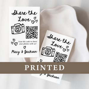 K&ouml;nnte beinhalten: Wei&szlig; bedruckte Karten mit dem Text "Share the Love" und einer Kamera-Grafik mit einem Herz. Enth&auml;lt einen QR-Code und die Namen "Macy & Jackson". Das Wort "PRINTED" ist ebenfalls sichtbar.