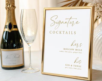 May include: A gold-framed sign with the words "Signature Cocktails" in elegant script. The sign lists "Moscow Mule" and "Gin & Tonic" cocktails. A champagne bottle and a champagne flute are next to the sign, suggesting a celebratory event.