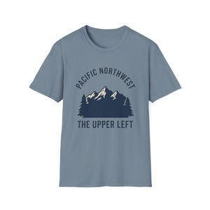 May include: A blue short-sleeve t-shirt with a graphic design. The design features a mountain range with the text "PACIFIC NORTHWEST" above and "THE UPPER LEFT" below in a dark blue color.