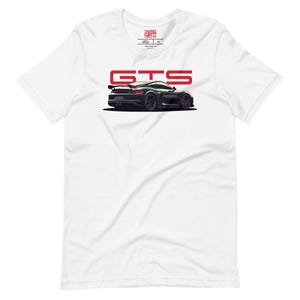 Könnte beinhalten: Ein weißes Kurzarm-T-Shirt mit einer Grafik eines dunkelgrauen Sportwagens in der Dreiviertel-Rückansicht. Über dem Auto ist der Text GTS in fetten roten Buchstaben gedruckt. Das innere Nackenetikett zeigt den Text SHIFTING LINES.