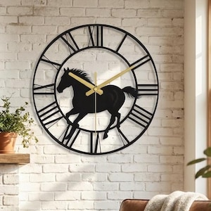 May include: A circular wall clock featuring a black metal frame with Roman numerals and a silhouette of a galloping horse in the centre. The clock has two thin, gold-coloured metal hands positioned against the black horse figure.