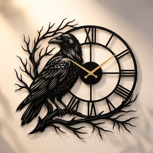 Peut inclure: Une horloge murale noire représentant la silhouette détaillée d'un corbeau perché sur une branche d'arbre dénudée. Le cadran présente un cadre circulaire avec des chiffres romains noirs et deux fines aiguilles dorées au centre.