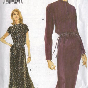 May include: A sewing pattern for a dress with two different styles. The first style is a floral print dress with short sleeves and a tie at the waist. The second style is a solid purple dress with long sleeves and a tie at the waist. The pattern is for sizes 8-10-12. The pattern is from Very Easy Vogue.