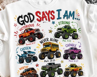 Puede incluir: Una camiseta blanca con el texto GOD SAYS I AM... e ilustraciones de seis camiones monstruo y un autobús escolar. Cada vehículo se acompaña de una palabra descriptiva y un versículo bíblico, incluyendo Victorious, Strong, Chosen, Never Alone, Capable y Worthy.