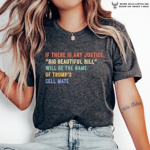 May include: A dark heather gray short-sleeve t-shirt featuring multi-colored text that reads: IF THERE IS ANY JUSTICE, BIG BEAUTIFUL BILL WILL BE THE NAME OF TRUMP'S CELL MATE. The shirt has a crew neckline and a standard fit.
