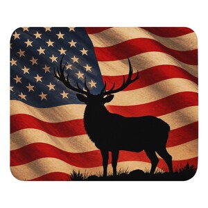 May include: A decorative item with a stag silhouette set against a waving American flag. The flag has red and white stripes and a blue section with stars. The stag is black, and the design has a vintage, patriotic appearance.