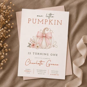 May include: A rectangular invitation card featuring the text "our little PUMPKIN IS TURNING ONE" and "Charlotte Grace". The design includes a central illustration of a white pumpkin adorned with a large pink bow and small floral accents.