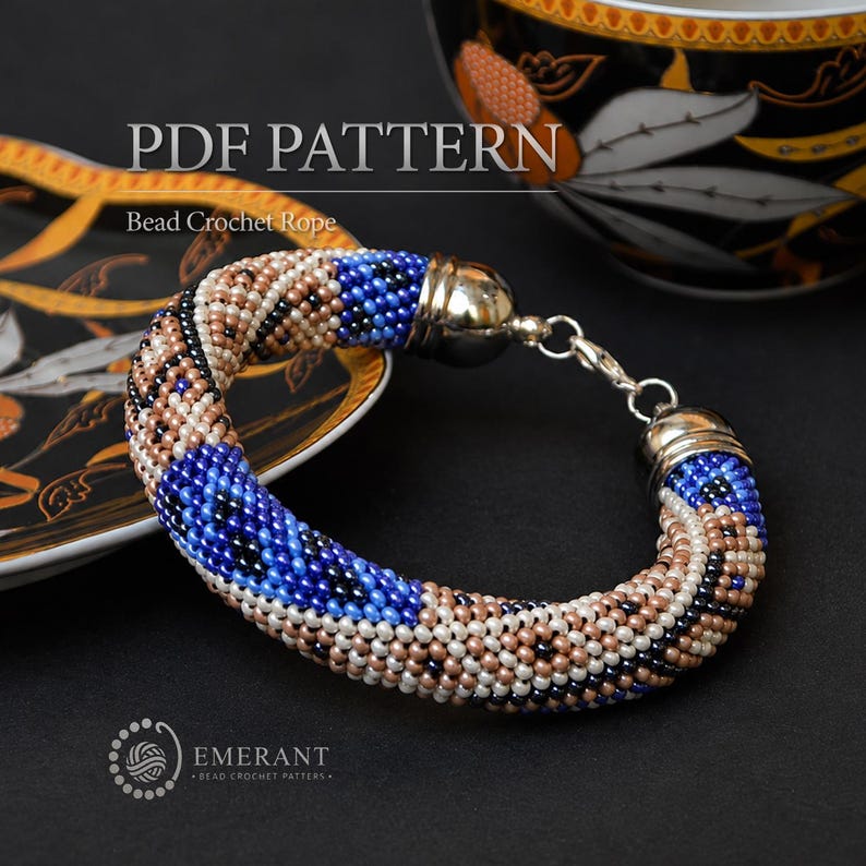 May include: A bead crochet rope bracelet featuring a geometric pattern in shades of blue, beige, black, and white. The bracelet has silver-toned metal end caps and a lobster claw clasp. The text PDF PATTERN Bead Crochet Rope is visible.