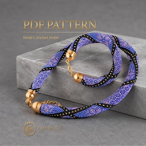 Puede incluir: Un conjunto de collar y pulsera de cuerda de cuentas tejidas a ganchillo con un patrón en espiral de cuentas de semillas moradas, rosas y negras. Las piezas tienen terminales de metal dorado pulido y cierre de langosta. Texto: PDF PATTERN.