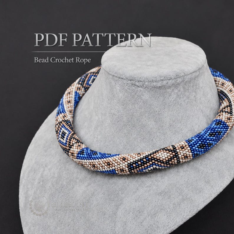 May include: A bead crochet rope necklace featuring a geometric pattern in shades of blue, beige, black, and white. The text PDF PATTERN Bead Crochet Rope is displayed above the necklace. The jewellery is displayed on a grey velvet display bust.