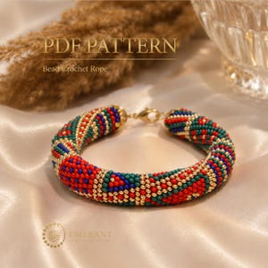 May include: A bead crochet rope bracelet featuring a geometric pattern of red, green, blue, and gold beads. The bracelet has a gold-tone metal lobster clasp. The text PDF PATTERN Bead Crochet Rope is visible at the top of the image.