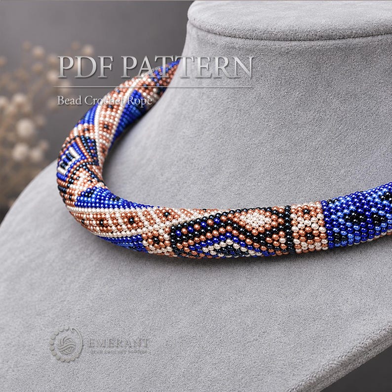 May include: A bead crochet rope necklace featuring a geometric pattern in shades of blue, metallic copper, and black. The text PDF PATTERN Bead Crochet Rope is visible at the top, and the Emerant logo is visible at the bottom left corner.