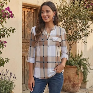 May include: A long-sleeve shirt featuring a tan, brown, and white plaid pattern with a quarter-zip neckline and two chest pockets. The shirt has a collarless design and three-quarter length sleeves with buttoned tabs, paired with blue denim jeans.