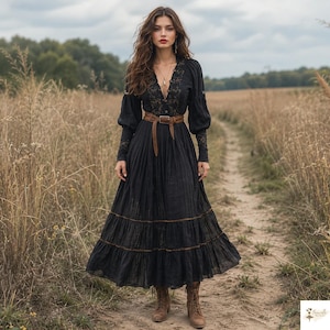 May include: A long-sleeved black maxi dress featuring a deep V-neckline with intricate lace detailing, a button-down front, and a tiered skirt. The dress is cinched at the waist with a brown leather belt and paired with brown lace-up ankle boots.