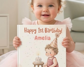 May include: A square hardcover book with a white cover featuring the text Happy 1st Birthday! Amelia in brown letters. The illustration shows a baby wearing a party hat sitting next to a small stool with a birthday cake and a single candle.