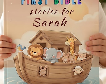 May include: A hardcover book titled FIRST BIBLE stories for Sarah featuring a wooden ark filled with cartoon animals including a lion, elephant, giraffe, rabbits, and sheep on a light-colored background with a sun and soft clouds.