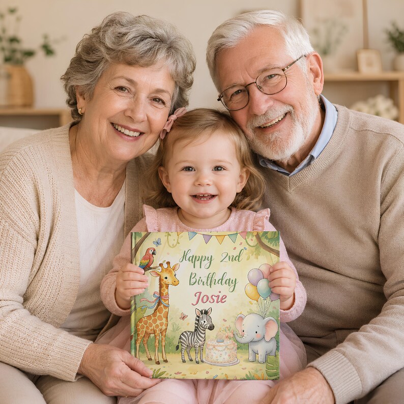 May include: A square hardcover book with a light yellow cover featuring a giraffe, a zebra, and an elephant. The text reads Happy 2nd Birthday Josie. The illustration includes colorful balloons, a parrot, and a birthday cake in a jungle setting.
