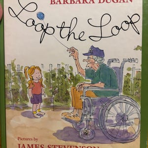May include: A hardback children's book titled Loop the Loop by Barbara Dugan with pictures by James Stevenson. The cover features a watercolour illustration of a young girl with a ponytail and an older person in a wheelchair playing with a blue yo-yo.