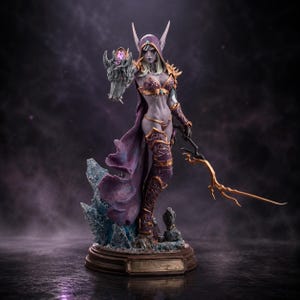 以下が含まれることがあります： 長い白髪を持つ青白いエルフのようなキャラクターの精巧なファンタジーフィギュア。紫色のフード付きマントと金色の装飾が施された鎧を身に着けている。キャラクターは紫色の宝石が付いた灰色の狼の頭のガントレットと、枝分かれした金色の杖を持っている。
