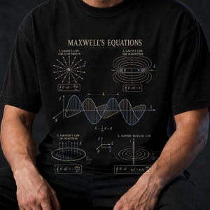 May include: A black t-shirt featuring a white graphic print of Maxwell's Equations. The design includes diagrams for Gauss's Law for Electricity, Gauss's Law for Magnetism, Faraday's Law of Induction, and Ampere-Maxwell Law with mathematical formulas.