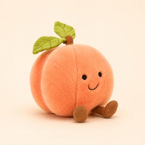 May include: A plush peach toy with soft orange fabric, featuring two green fabric leaves on top and a brown stem. The peach has a stitched smiling face with small black eyes and a curved mouth, along with two small brown corduroy legs extending forward.