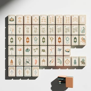 May include: A set of rectangular mahjong tiles featuring cream-colored faces with intricate illustrations of lotus flowers, bamboo stalks, lanterns, and various animals. The tiles include numbered suits, joker tiles with unique designs, and directional tiles.