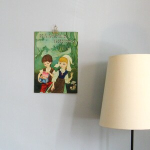 May include: Vintage children's book cover featuring two children, a boy and a girl, in a woodland setting. The book title is "Hansel & Gretel".
