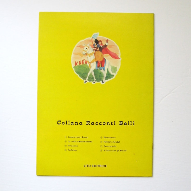 May include: A yellow book cover featuring an illustration of a prince and princess riding a white horse. The book title is "Collana Racconti Belli" and lists the following titles: Cappuccetto Rosso, La bella addormentata, Pinocchio, Pollicino, Biancaneve, H&auml;nsel e Gretel, Cenerentola, and Gatto con gli Stivali. The book is published by Lito Editrice.
