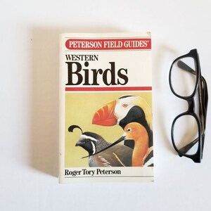 May include: A Peterson Field Guides book titled "Western Birds" featuring illustrations of a puffin, a quail, and a sandpiper. The book cover is yellow with black text.