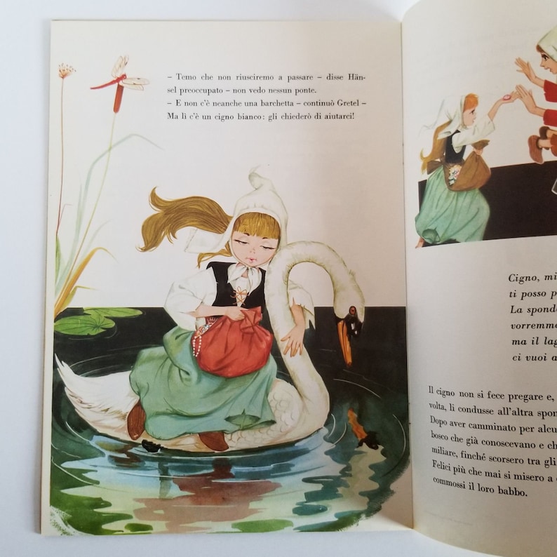 May include: A young girl in a white dress and a red bag sits on a white swan. The swan is swimming in a blue pond with green lily pads. The girl has blonde hair and blue eyes. The text in the image reads: "Temo che non riusciremo a passare - disse H&auml;nsel preoccupato - non vedo nessun ponte. - E non c'&egrave; neanche una barchetta - continuo Gretel - Ma li c'&egrave; un cigno bianco: gli chieder&ograve; di aiutarci!"