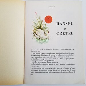 May include: An illustrated book cover featuring a white swan swimming in a pond with green reeds and a red sun in the background. The title of the book is "HANSEL e GRETEL" in large, bold letters.