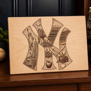 May include: A rectangular light-colored wooden plaque featuring a laser-engraved New York Yankees logo. The interior of the logo contains detailed illustrations of the Statue of Liberty, the Brooklyn Bridge, baseball bats, a ball, and a cap.