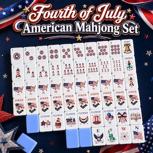 Puede incluir: Un juego de Mahjong americano del 4 de julio con fichas blancas adornadas con dise&ntilde;os rojos, blancos y azules. Las fichas muestran n&uacute;meros, cohetes, banderas americanas y s&iacute;mbolos patri&oacute;ticos. Incluye atriles azules y las palabras "Joker" y "Flower".