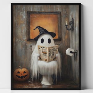 May include: A framed wall art print featuring a white ghost wearing a black witch hat, sitting on a toilet and reading a newspaper titled Halloween Ghost Sighting. A carved orange jack-o'-lantern sits on the floor next to a toilet paper roll.
