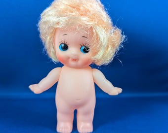Small Vinyl Kewpie-like Doll 4" marked TBN in diamond, nude, has wings - blonde hair, blue eyes