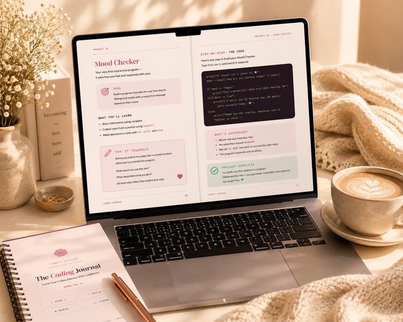 May include: A laptop screen displaying a coding tutorial titled Mood Checker with text about building a programme, alongside a spiral-bound notebook titled The Coding Journal, a cup of coffee, and a vase of dried flowers on a desk surface.