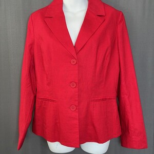 May include: A bright red blazer with a notched lapel, three-button closure, and two front pockets. The blazer is displayed on a white mannequin and has long sleeves. The fabric appears to be a woven material.