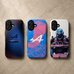 May include: Three smartphone cases featuring Alpine F1 team branding. The left case is dark blue with a small race car graphic. The centre case has a blue and pink abstract pattern with a white Alpine logo. The right case shows a driver in a racing suit.
