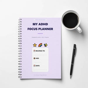 May include: A light purple spiral-bound planner titled MY ADHD FOCUS PLANNER. The cover features a star, rainbow, and sparkle icon, with a white box containing fields for BELONGS TO, AGE, and DATE, each marked with a small calendar or cake icon.