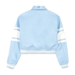 May include: A light blue varsity jacket featuring a classic collar, long sleeves with wide white horizontal stripes, and ribbed knit cuffs and hem with white and light blue stripes. The jacket has a smooth finish and a structured, cropped silhouette.