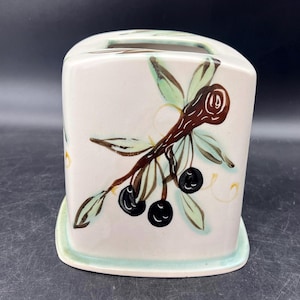 May include: A white ceramic tissue box cover with a green and brown olive branch design. The olives are painted in black.