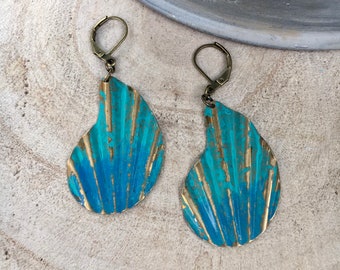 May include: A pair of blue and gold earrings with a shell design. The earrings are made of metal and have a distressed finish.
